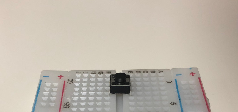 Push button fully inserted into breadboard