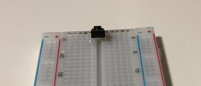 Push button partially inserted into breadboard