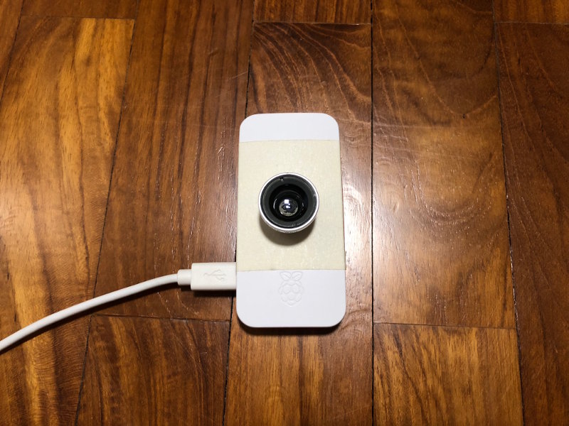 Raspberry Pi Zero W with 0.67x wide angle lens being placed on wooden floor