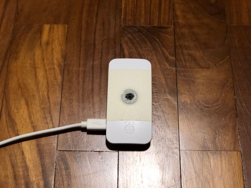 Raspberry Pi Zero W with magnetic adapter ring being placed on wooden floor