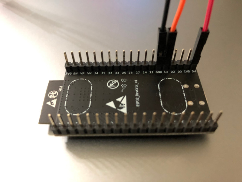 Underside of ESP32 development board with GPIO cables connected to GND GPIO13 and 5V