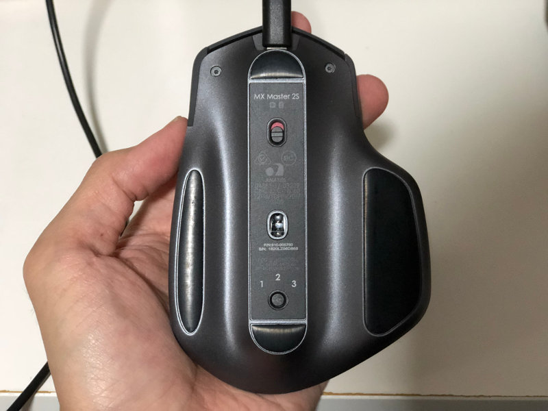 Underside of Logitech MX Master 2S wireless mouse with microUSB cable and was being switched off