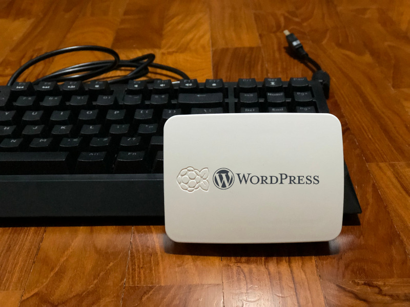 WordPress logo on a Raspberry Pi case and a keyboard at the background