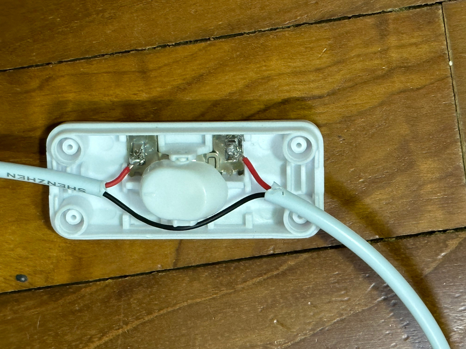 red wires coiled onto metal conductors on inline cord switch