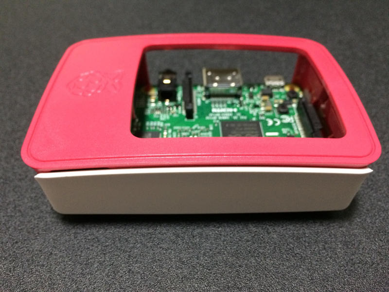 Smooth white piece of Official Case attached with red parts and Raspberry Pi 3 board